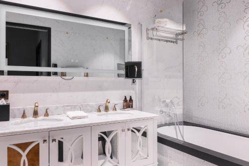 a bathroom with two sinks and a mirror and a tub at Juliana Hotel & Spa - Brussels Centre in Brussels