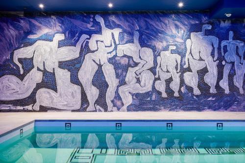a swimming pool with a painting on the wall at Juliana Hotel & Spa - Brussels Centre in Brussels