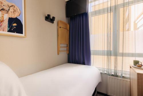 a small bedroom with a bed and a window at Leonardo Hotel Amsterdam Leidse Square in Amsterdam