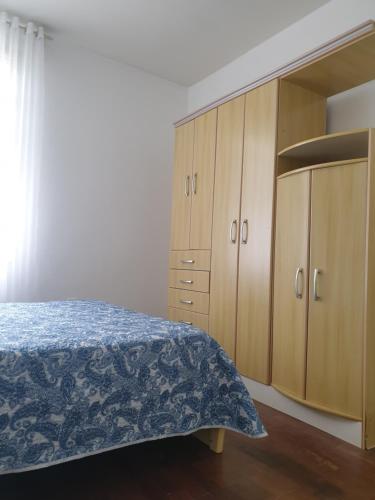 a bedroom with a bed and wooden cabinets at Casa Feliz in Campo Alegre