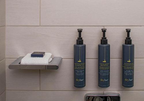 a group of three shampoo bottles on a wall at aloft Green Bay in Green Bay