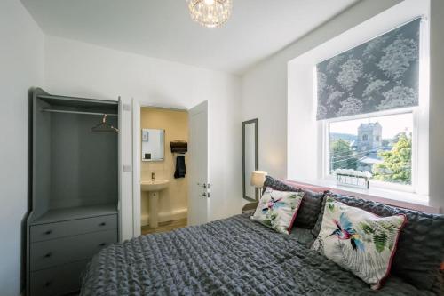 a bedroom with a bed and a window at Village View - Free access to local Health Club in Bowness-on-Windermere