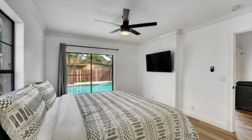 um quarto com uma cama e uma ventoinha de tecto em Delray Escape Pool Renovated Sleeps 12 em Delray Beach