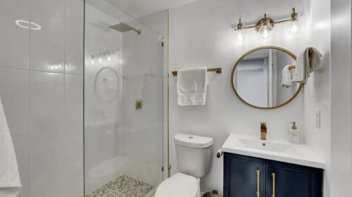 uma casa de banho com um chuveiro, um WC e um lavatório. em Delray Escape Pool Renovated Sleeps 12 em Delray Beach