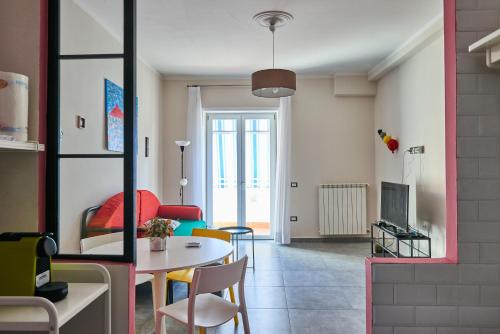 Pupatella Apartments في نابولي: غرفة معيشة مع طاولة وكراسي