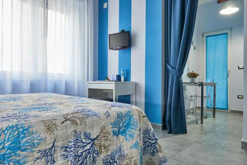 a bedroom with blue walls and a bed and a tv at Pupatella Apartments in Naples