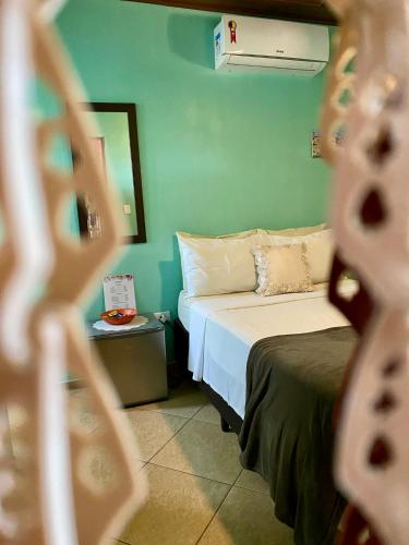a small room with a bed and a night stand at Pousada do Tom in Lençóis