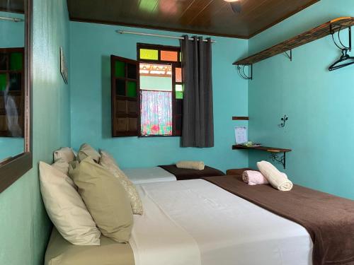 a bedroom with a large bed with blue walls at Hospedaria do Tom in Lençóis