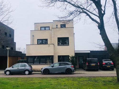 two cars parked in front of a building at City Zen Apartment Enschede !Free Private Parking in Enschede