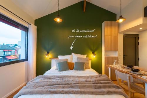 une chambre avec un grand lit avec un mur végétal dans l'établissement Studio Mansart, à Bagneux