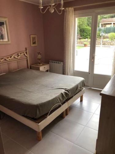 une chambre avec un lit et une porte coulissante en verre dans l'établissement Propriété avec deux logements, à Forcalqueiret
