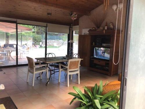 une salle à manger avec une table, des chaises et une télévision dans l'établissement Propriété avec deux logements, à Forcalqueiret