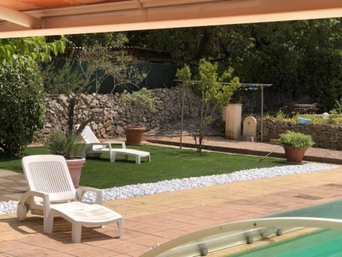 un patio avec deux chaises et une piscine dans l'établissement Propriété avec deux logements, à Forcalqueiret