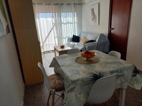a living room with a table with a bowl of fruit on it at Appartement proche mer in Santiago de la Ribera
