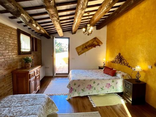 a bedroom with two beds in a room with yellow walls at Casa Mas Molines in Montrás