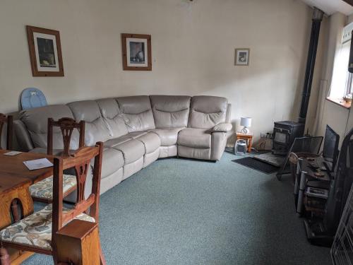 a living room with a couch and a table at Rosecare Barn in Bude