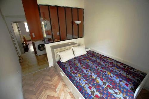 um quarto com uma cama com uma colcha colorida em Appartement de caractére, proche palais des papes em Avignon