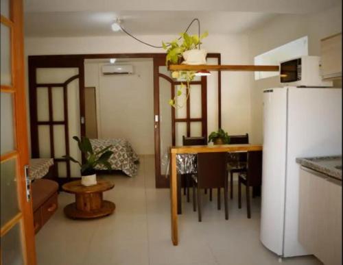 een keuken met een tafel en een witte koelkast bij Estúdios Mangueiras in Florianópolis