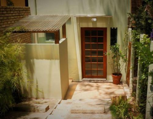 een klein huis met een deur en een plant bij Estúdios Mangueiras in Florianópolis
