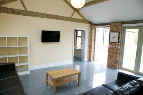 a living room with a couch and a coffee table at Pheasants Roost at Tove Valley Cottages in Towcester