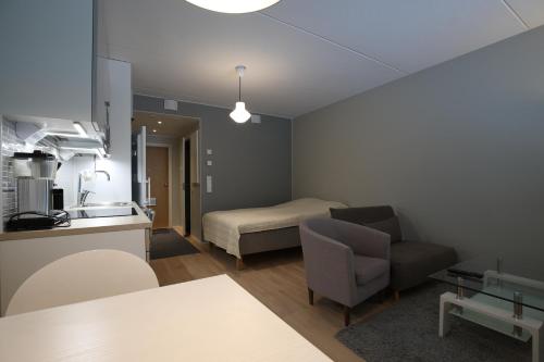 Habitación con cocina, cama y sofá en Hieno yksiö Tapiolan urheilupuistossa., en Espoo