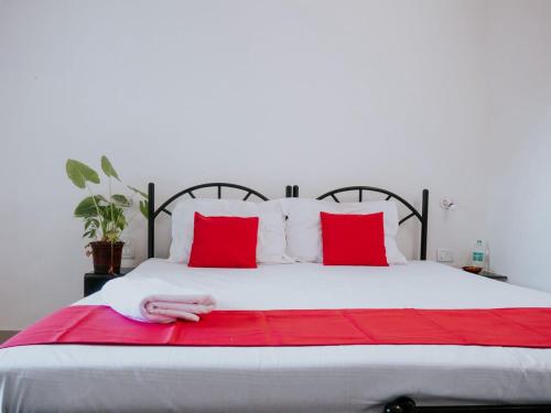 a bed with red pillows and a red blanket at C9 Anjuna in Anjuna