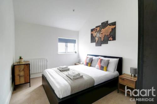 a bedroom with a large bed with white sheets at Lovely 1 Bedroom Flat with Free Off Road Parking in Chesterton