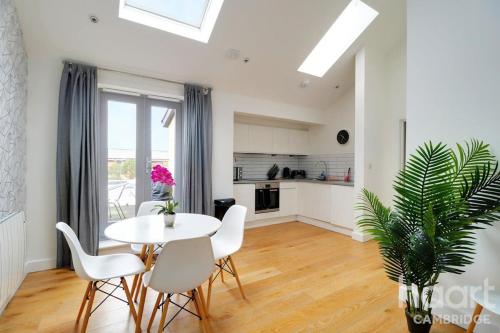 a living room with a table and chairs and a kitchen at Lovely 1 Bedroom Flat with Free Off Road Parking in Chesterton