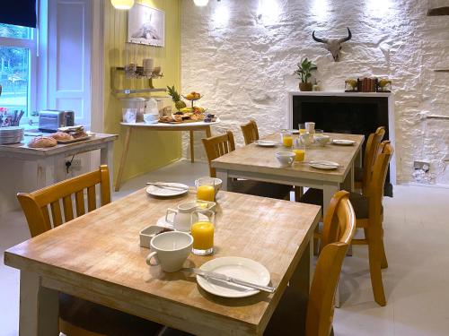 a dining room with two wooden tables and chairs at Red Lion, Coorie Inn in Earlston