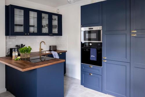 a kitchen with blue cabinets and a wooden counter top at Blå Huset in Vaxholm