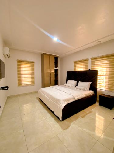 a bedroom with a large bed in a room with windows at Service apartment is Abuja in Abuja