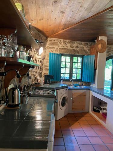 a kitchen with a stove and a washing machine at Quinta Abelha in Três Horas