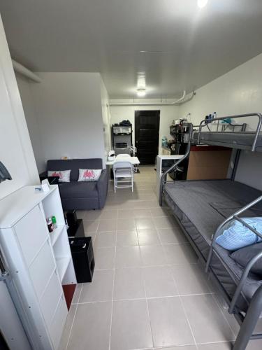 Zimmer mit 2 Etagenbetten und einem Sofa in der Unterkunft Near Mactan Airport and Indiana Aerospace University, Lapu Lapu City in Pajak