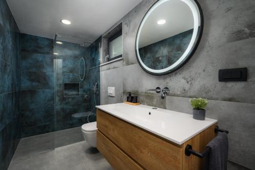 La salle de bains est pourvue d'un lavabo et d'un miroir. dans l'établissement Beautiful Villa Lakora with pool in Porec, à Kirmenjak