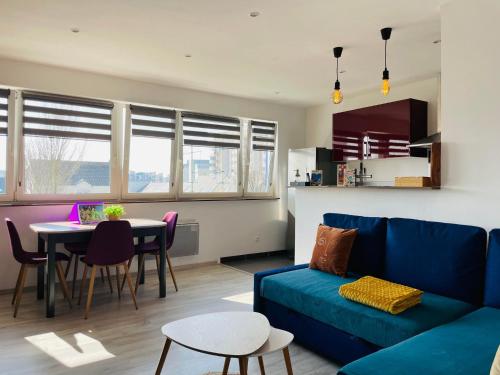 un salon avec un canapé bleu et une table dans l'établissement La Brise Marine, à Calais