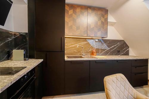 a kitchen with black cabinets and a sink at 20% Discount! 2 Bedroom Apartment Vitosha View in Sofia