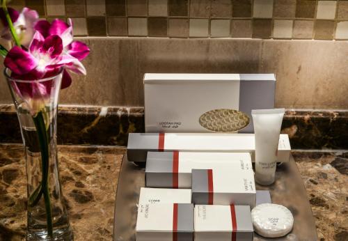 a vase with a flower and a box on a table at First Central Hotel Suites in Dubai