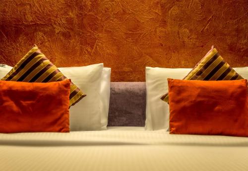 a bed with three pillows on it with at First Central Hotel Suites in Dubai
