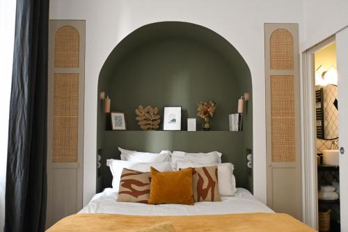 a bedroom with a bed with a green headboard at Maison Fernand B&B in Bordeaux