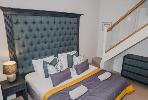 1 dormitorio con 1 cama grande y cabecero grande en The Kinross Residence en Kinross