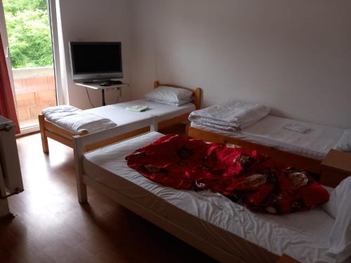 a room with three beds and a flat screen tv at HOTEL WIEN in Barakovići