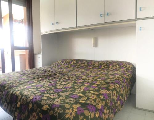 een slaapkamer met een bed met een bloemenbed bij La Maison du Port - Apartment with Pool in Manerba del Garda