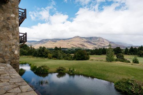 a view of a river with mountains in the background at Loi Suites Chapelco Hotel in San Martín de los Andes