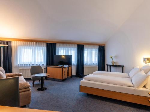 une chambre d'hôtel avec un lit et une télévision dans l'établissement B&B HOTEL Eschweiler, à Eschweiler