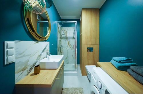 een badkamer met een wastafel en een spiegel bij 4 Styles Apartment Rose z miejscem postojowym w garażu podziemnym in Toruń