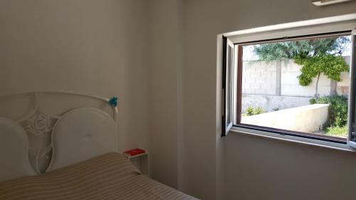 サンタ・マリネッラにあるAurelia Apartment by the seaのベッドルーム(ベッド1台、窓付)