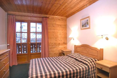 une chambre avec un lit et une grande fenêtre dans l'établissement Alpina Lodge - 02 - Appart rdc duplex - 8 pers, à Les Deux Alpes