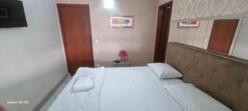 a bedroom with a large white bed in a room at Pousada do Farol Bar e Restaurante in Vila Velha