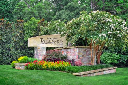 a sign for the entrance to a garden with flowers at Excelsior at the Manor House in Clemmons