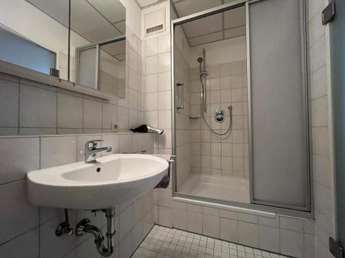 La salle de bains est pourvue d'un lavabo et d'une douche. dans l'établissement Simplex Apartments Am Ludwigsplatz, à Karlsruhe